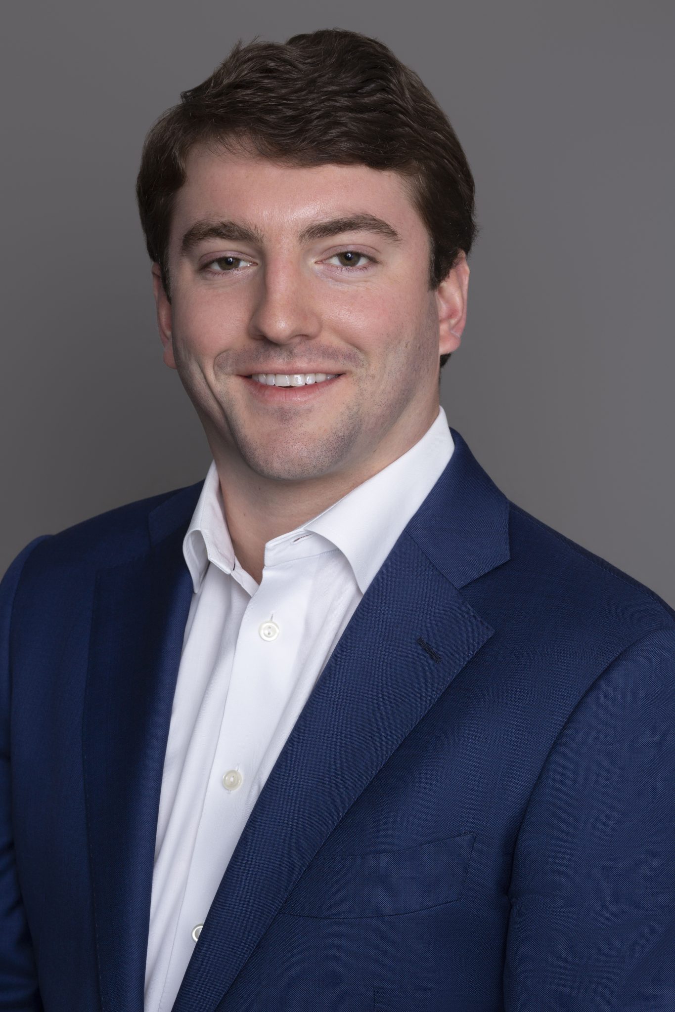 William Heck headshot - wearing a blue suit jacket and a white dress shirt